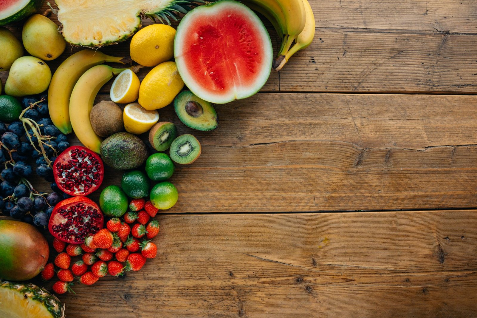 Anguria, banane e altra frutta fresca colorata su un tavolo di legno