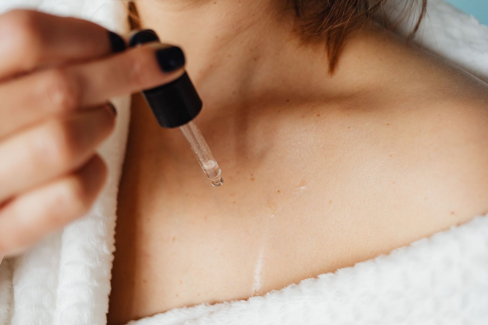 Una mano sfiora la clavicola e il collo, gesto di cura al mattino