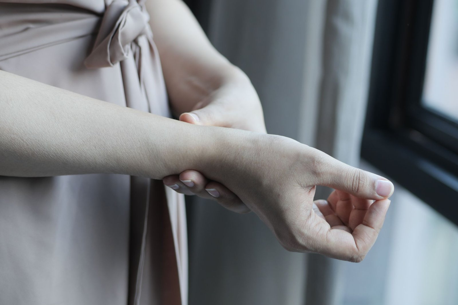 Una mano tiene delicatamente il polso e l'avambraccio