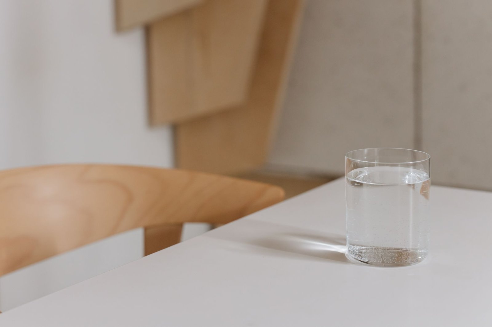 Un bicchiere d'acqua pieno su un tavolo di legno di cucina