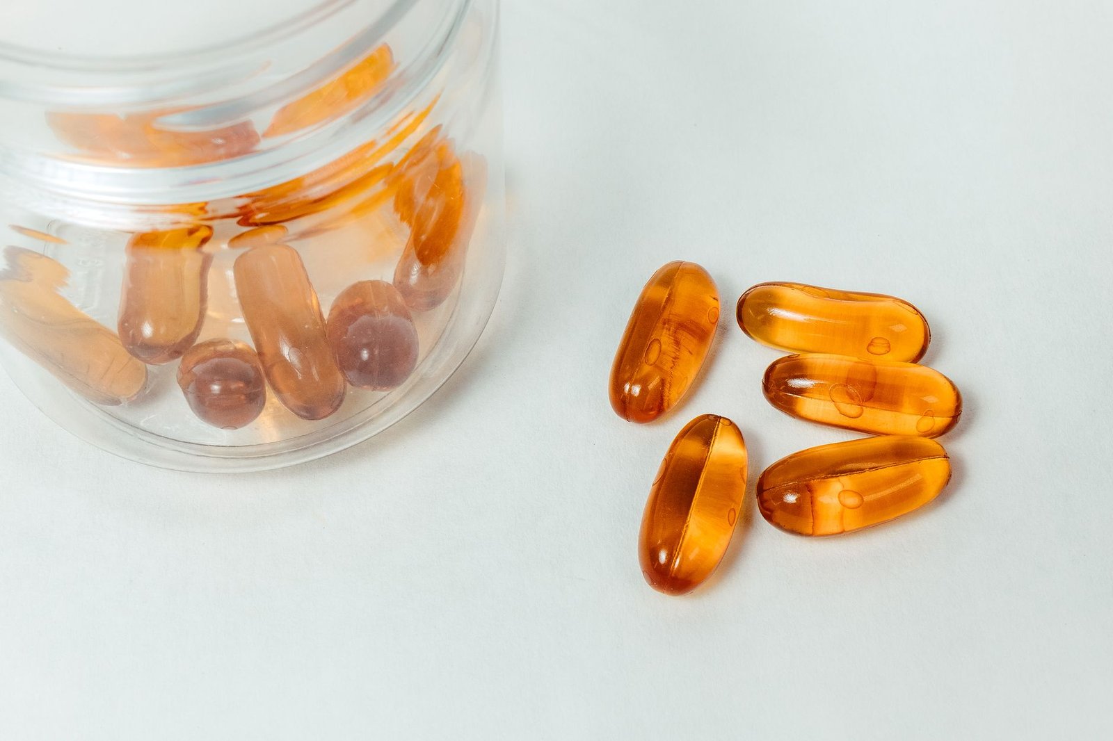 Capsule drenanti che escono da un barattolo di vetro, come quelle comprate in farmacia