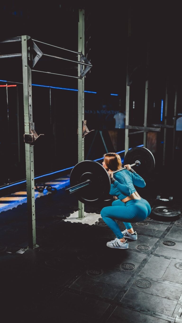 Donna esegue uno squat con bilanciere in palestra