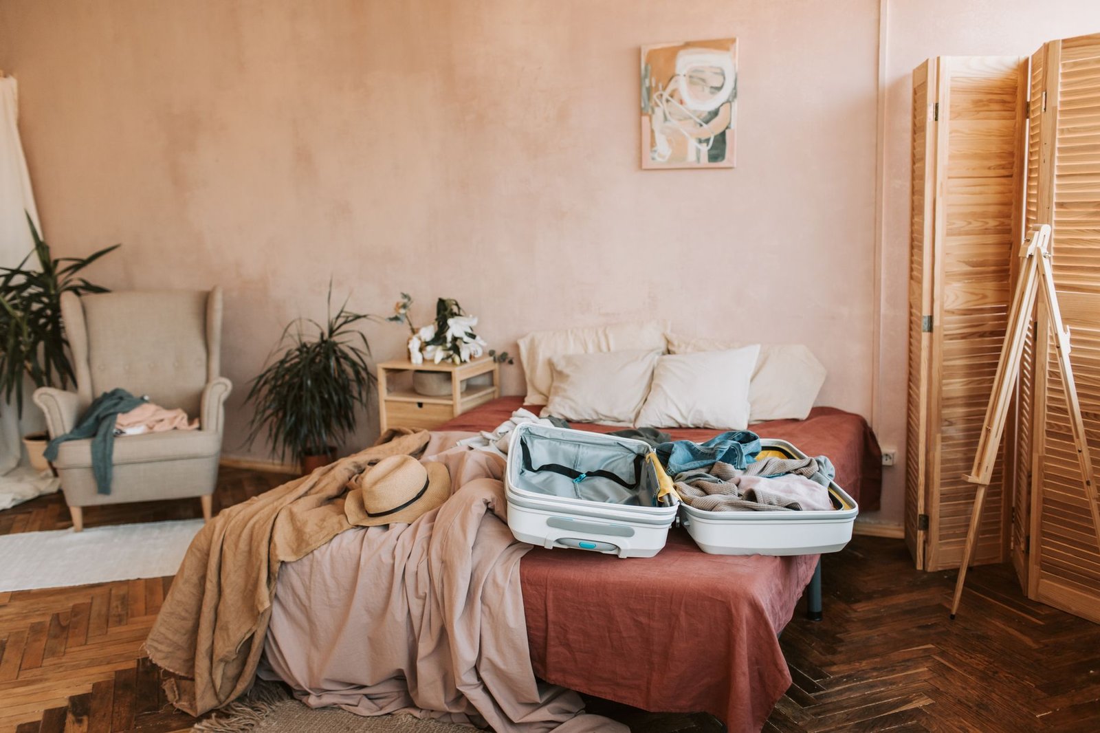 Valigia aperta su un letto, in una camera calda e accogliente, pronta per partire